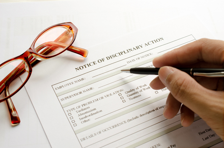 A person filling out a notice of disciplinary action. 
