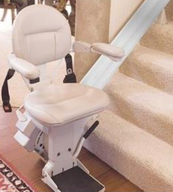 Stairway chairlift in the Unfolded, usable position at the base of a set of stairs.