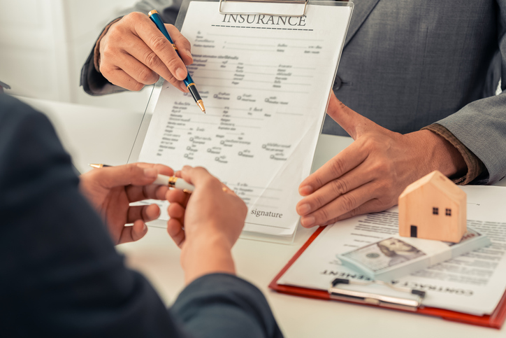 The real estate agent discussed the terms of the home purchase contract and asked the client to sign the document to legally complete the contract.

