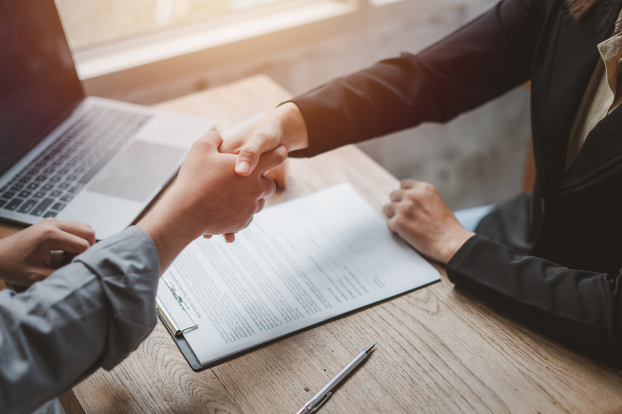 Business negotiations. Women shaking hands with clients after signing contracts. 

