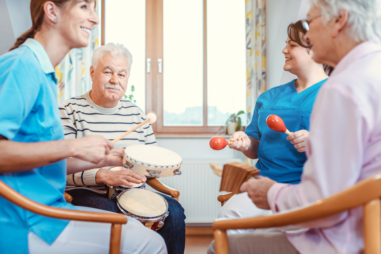 Seniors in nursing home making music with rhythm instruments as musical therapy