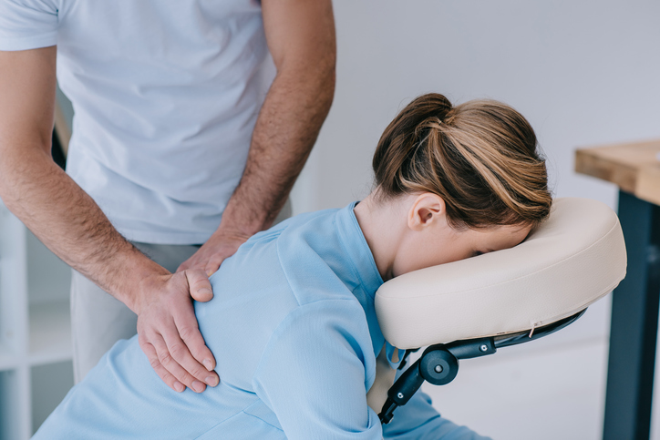 Close-up shot of masseur massaging back of female client.

