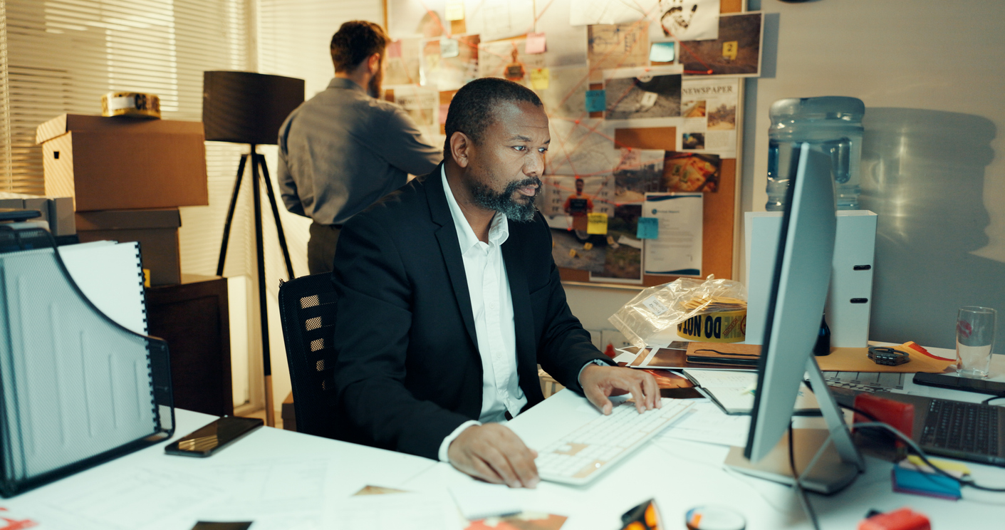Man, computer and detective in office with research for case, search for lead or problem solving.