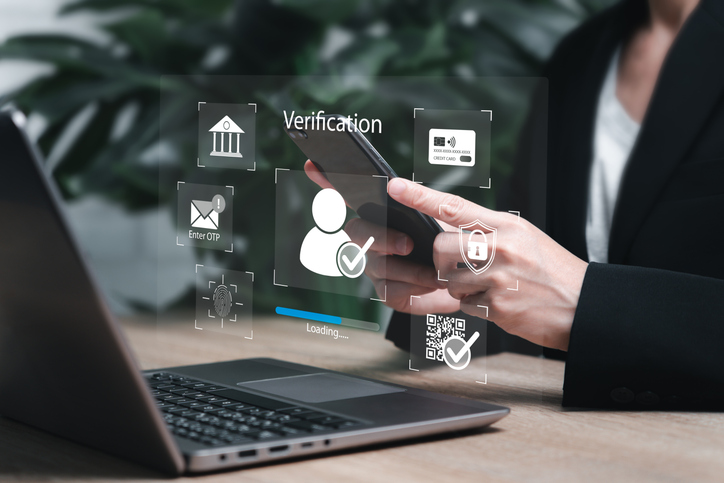 A person sitting in front of a computer showcasing the word verification with various digital images surrounding it.