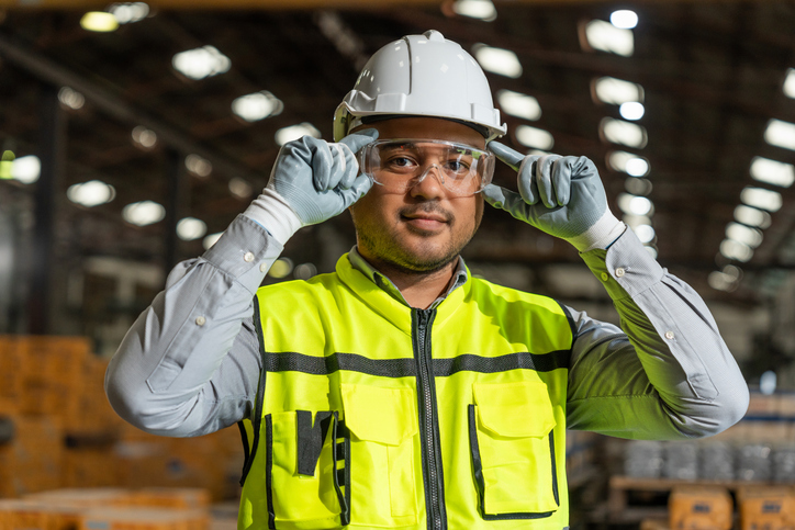 Technician engineer wearing and adjusting protective safety glasses.