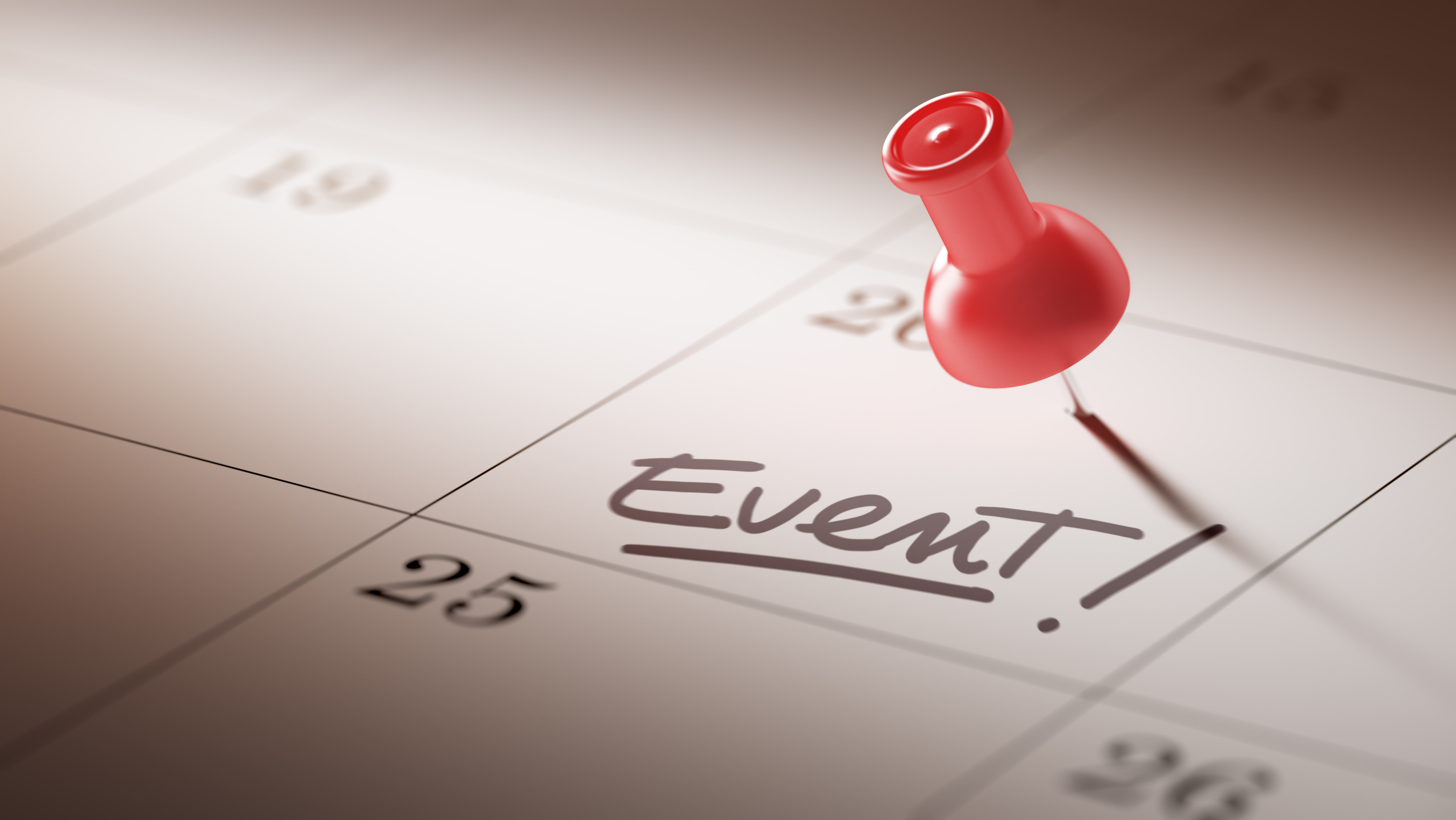A picture of a calendar with "Event!" written. There is a red pushpin on the date.