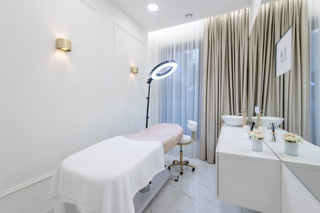 Minimalistic white spa room interior with treatment table