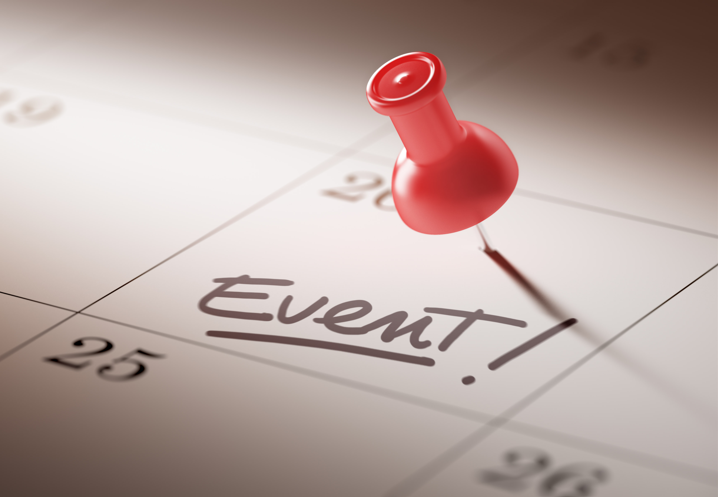 Paper calendar with a red thumbtack indicating an event
