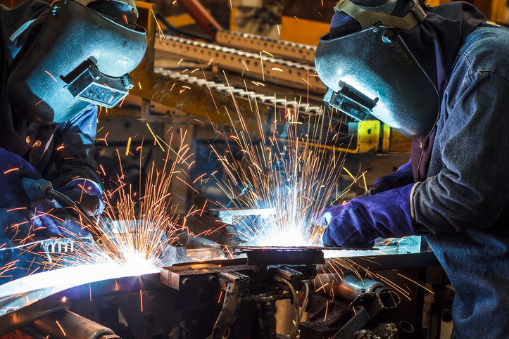Workers with protective mask welding metal.