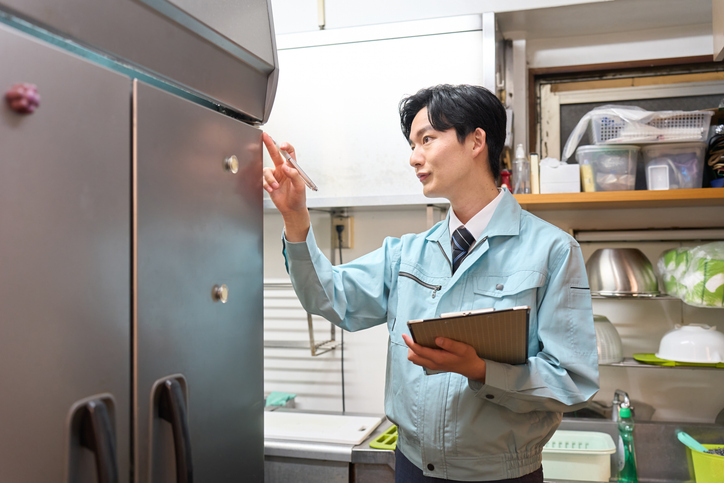 An inspector checking a restaurant's refrigerator.