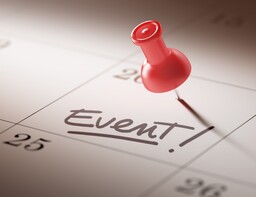 Red thumbtack in calendar with 'Event!' seemingly handwritten on the pinned date