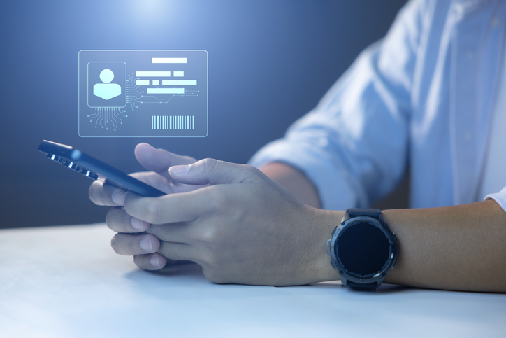 A person sitting down with their phone filling out personal details. 