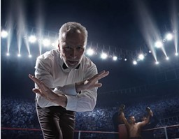 A referee at an unarmed combat sport event is crossing his arms in an "x."