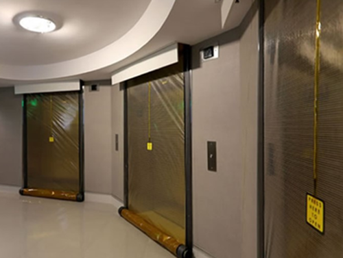 Three elevators with smoke curtains deployed. The curtains are see through and have a breakaway point. 