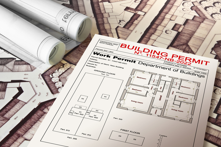 Image of Building Permit surrounded by additional blueprints.