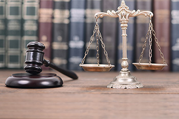 Picture of a gavel and a balance with books in the background