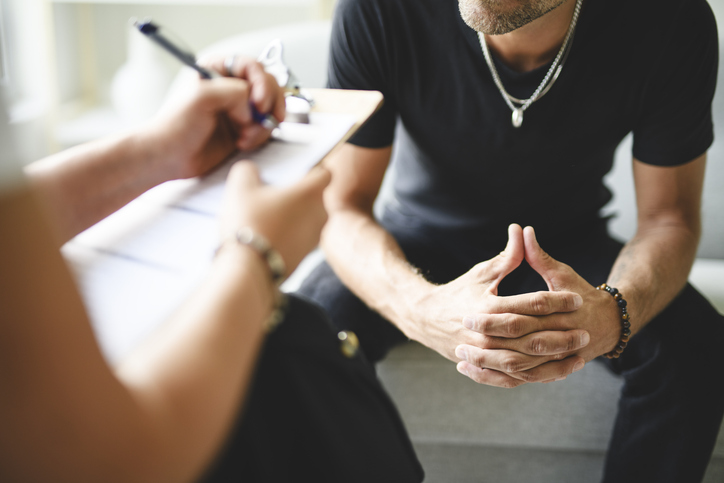 Man with female psychologist discussing drug addiction.

