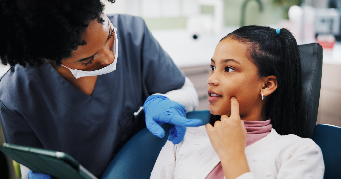  Child and a dental therapist with tablet for consultation. 