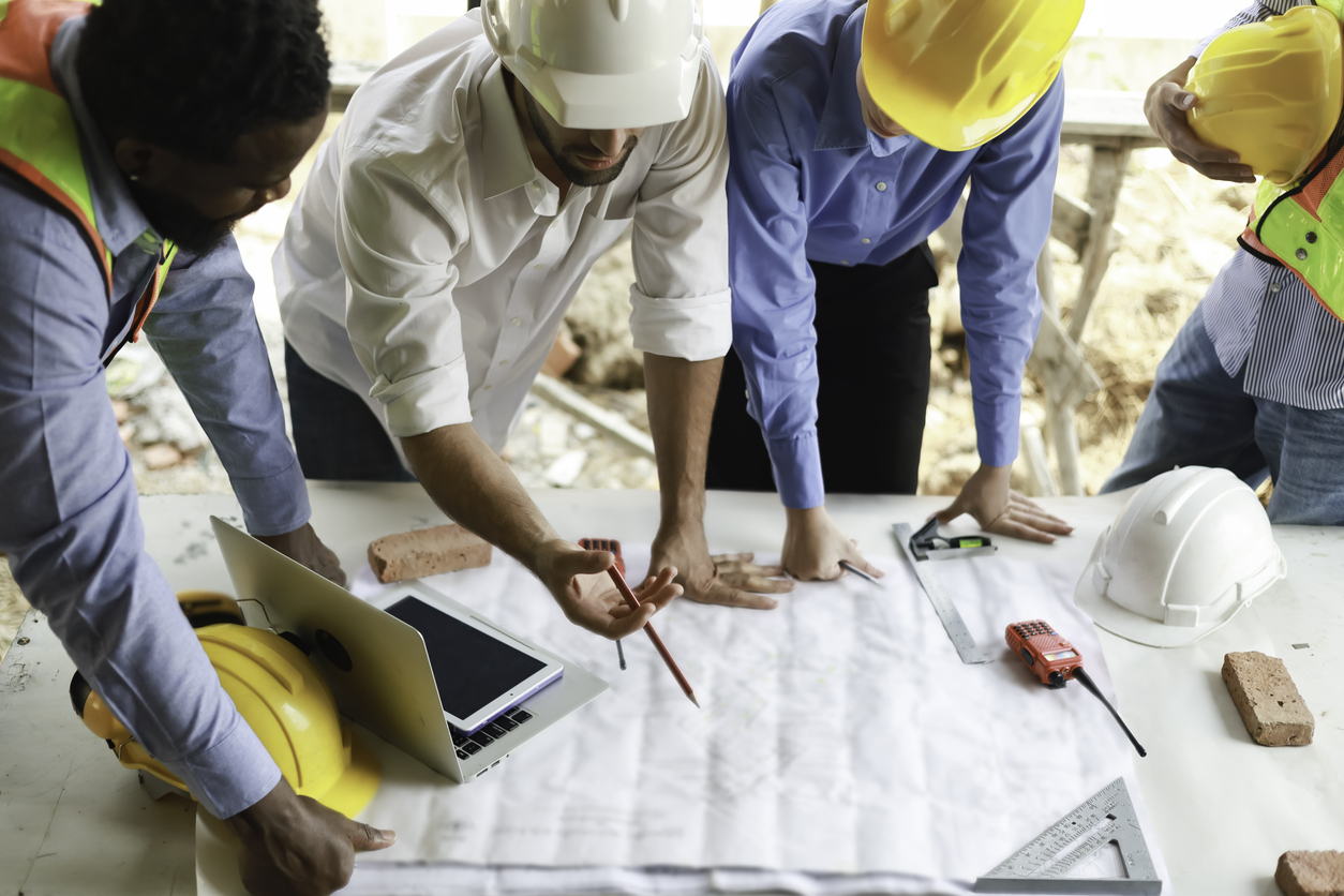A group of engineers and staff met to discuss and work together to assess the progress of the construction site.