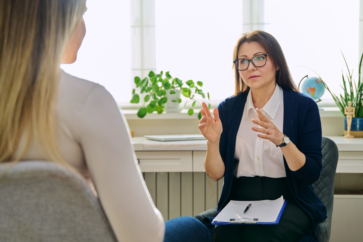 Middle aged female therapist working with a young woman in session therapy