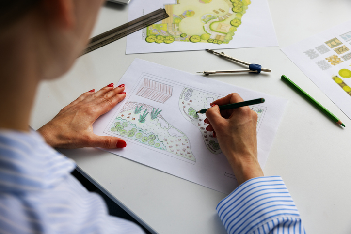Architect reviewing landscaping plans on a piece of paper.  