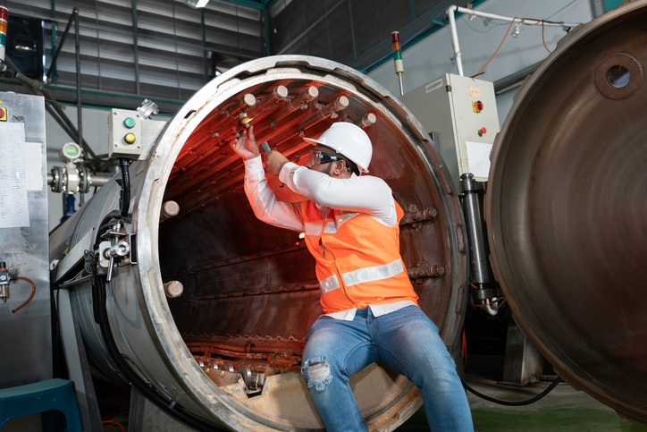 Maintenance engineer inspection at the pressure tank during plant shutdown.